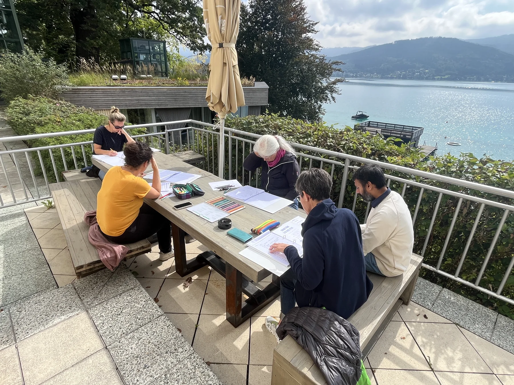Gemeinsame Reflexion beim Purpose-to-Impact-Seminar auf einer Terrasse mit Blick auf den Attersee